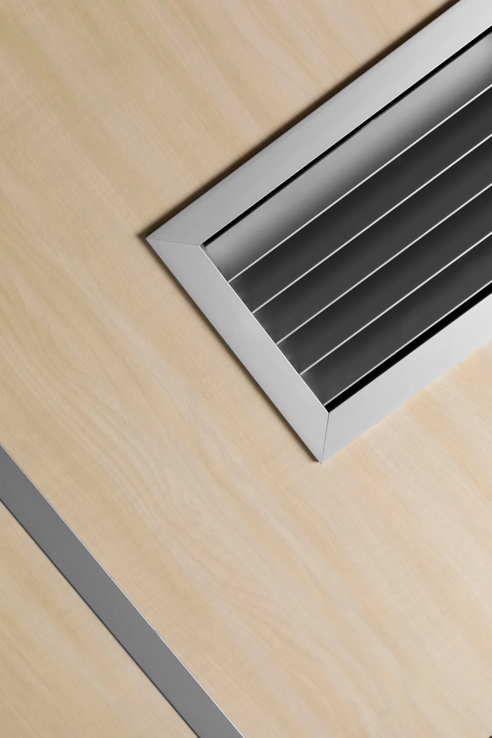 Metal ventilation grille fitted into a timber-lined ceiling